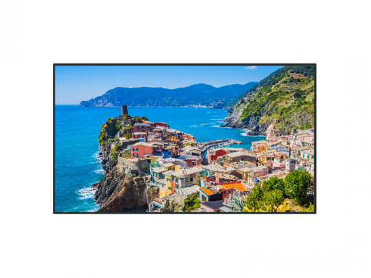 Colorful coastal village houses perched on a rocky cliff above the vibrant blue sea, with lush green hills and mountains in the background under a clear sky. Ideal wall art or poster for home decor featuring scenic seaside landscape.