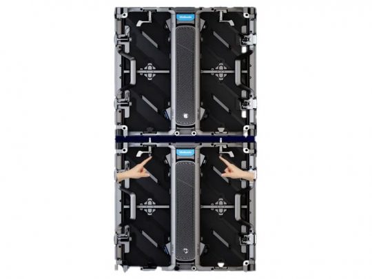 Two stacked Unilumin URMIII 2.6 MK2 Pro LED wall panels, each with a 2.6mm pixel pitch, are shown from the back on a white background; two hands point at the connection gap between modules, highlighting assembly or alignment of the visible back mechanisms.