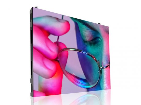 Close-up of a large digital display screen featuring a vibrant, high-contrast image of a person holding eyeglasses near their face. The display showcases bold pink, blue, and green lighting effects, highlighting the vivid color quality and sharp resolution—ideal for advertising or media presentations.