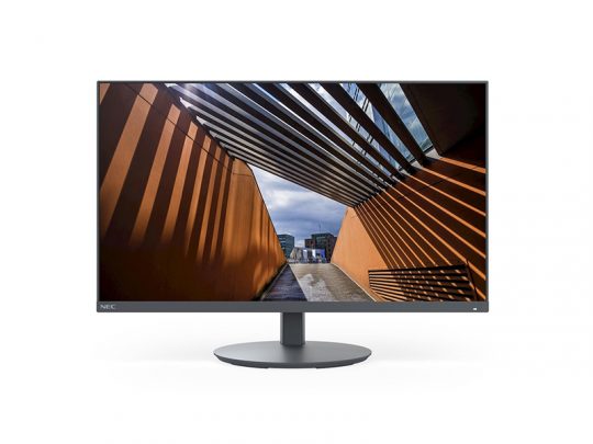 Computer-Monitor zeigt ein Foto einer modernen Architektur mit orangefarbenen Wänden und einem schattenspendenden Lamellendach; im Hintergrund sind weitere Gebäude unter einem bewölkten Himmel zu sehen. Ideal als hochauflösender PC-Bildschirm für Architektur- und Design-Präsentationen.