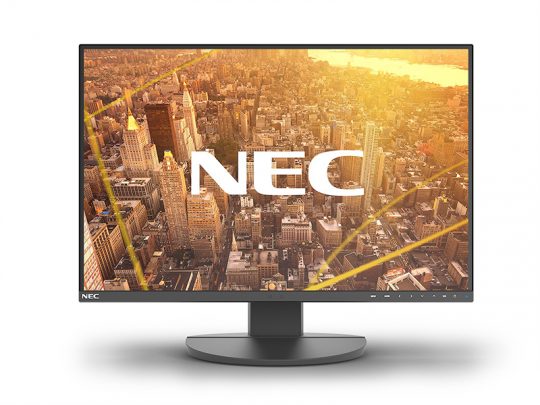 Schwarzer NEC Computermonitor (Modell nicht näher spezifiziert) mit dünnem Rahmen und flachem, rundem Standfuß. Auf dem Bildschirm ist eine Luftaufnahme einer Stadt-Skyline bei Sonnenuntergang mit eingeblendetem weißen NEC-Logo zu sehen.