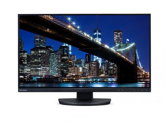 Sharp Flachbildschirm-Monitor zeigt eine nächtliche Stadtansicht mit beleuchteter Hängebrücke und erleuchteten Hochhäusern vor dunkelblauem Himmel. Produktbild für modernen Sharp Computer Monitor mit brillanter Farbdarstellung.