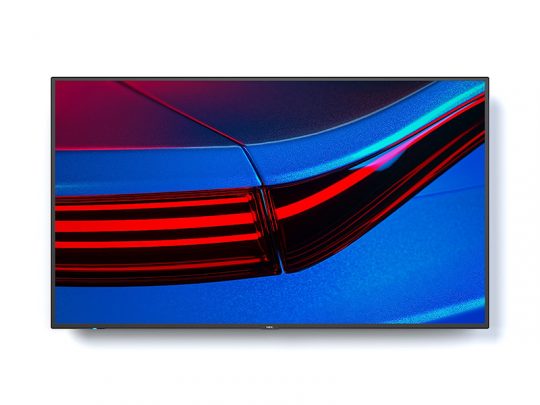 Flachbildfernseher, Modell nicht angegeben, zeigt auf dem Bildschirm eine Nahaufnahme eines roten und schwarzen Auto-Rücklichts vor blauem Hintergrund. Der moderne TV steht frei und hebt die Farbdarstellung sowie Bildschärfe hervor.